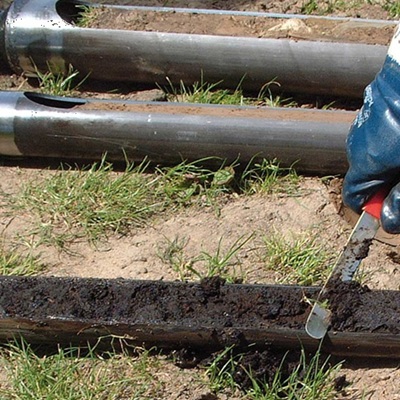 A Soil sampling auger with a gouge head. Showing it containing recently extracted undisturbed soil samples during mineral exploration.